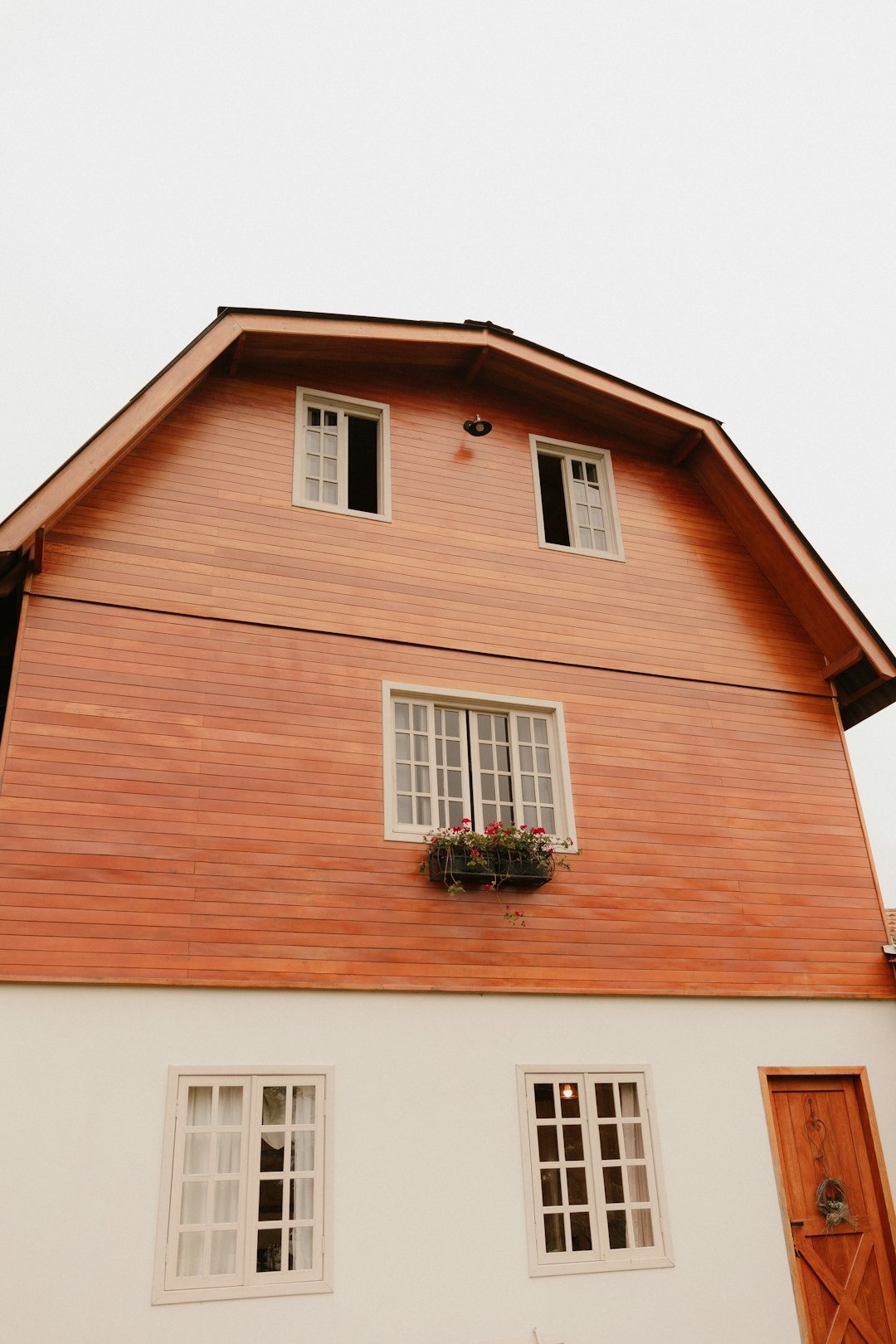 A wooden house with white windows and a door